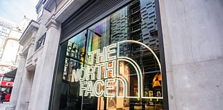 VF Corporation 與 Nedap 展開合作,旨在於全球門市實現端到端的庫存可視性 The North Face storefront with a large neon logo in the window on a city sidewalk outside.